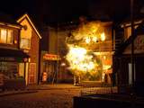 The factory explodes, showing the street in burning debris.