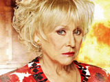 Peggy Mitchell in front of the burning Queen Vic in EastEnders