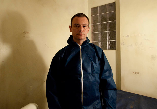Frank is put into a cell by the police