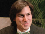 Steve Jobs in 1984, leaning on the new Macintosh personal computer