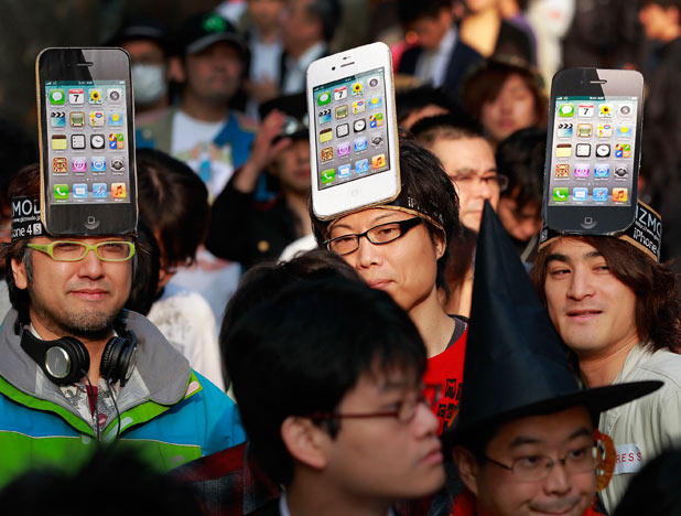 Apple Inc. fans wait in line in front of a shop in Tokyo