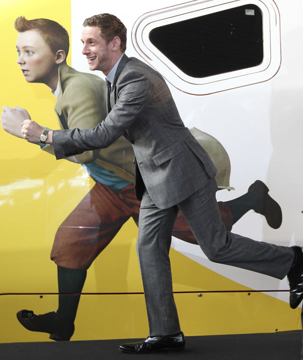 Jamie Bell poses next to cartoo...