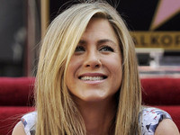 Jennifer Aniston poses atop her new star on the Hollywood Walk of Fame in Los Angeles