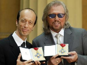 Robin and Barry Gibb hold their CBE's after receiving them from the Prince of Wales at Buckingham Palace, London