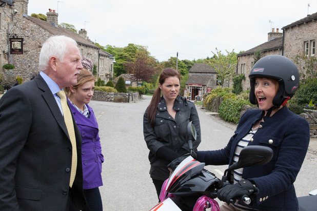 Val Pollard arrives on a moped
