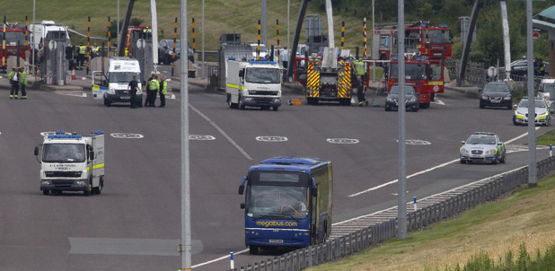 A bomb deposal van drives past a Megabus coach on the M6 toll motorway near Weeford, Staffordshire, after it was shut following a "police-led incident".