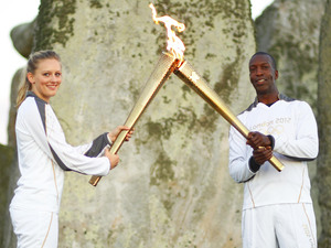 Michael Johnson holds the Olympic Torch at Stonehenge
