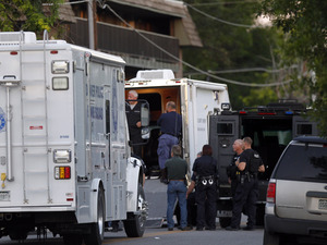 Police gather near an apartment house where the suspect in a shooting at a movie theatre lived in Aurora, Colorado