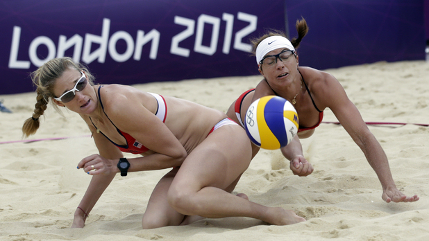 The United States's Misty May Treanor, right, dives over her teammate Kerri Walsh Jennings