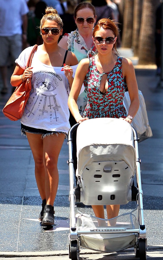 Une Healy takes her daughter for a stroll in California with Saturdays bandmate Vanessa White.