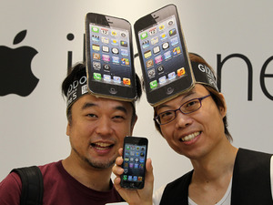 Customers wearing iPhone hats try out their new toys in the Apple store, Tokyo