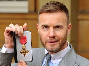 Gary Barlow holds his OBE, for services to the entertainment industry and to charity, which was awarded to him by Queen Elizabeth II during an Investiture ceremony at Buckingham Palace in central London.