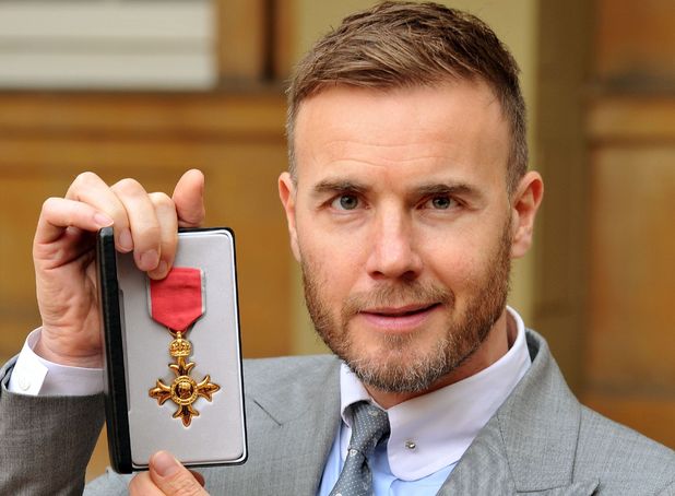 Gary Barlow holds his OBE, for services to the entertainment industry and to charity, which was awarded to him by Queen Elizabeth II during an Investiture ceremony at Buckingham Palace in central London.
