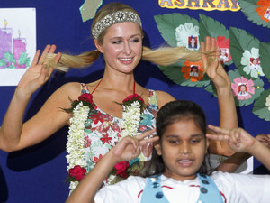 Paris Hilton, left, dances with children during her visit at Ashray, an orphanage in Mumbai, India, Monday, Dec. 3, 2012