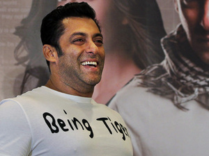 Salman Khan smiles as he stands in front of a poster showing himself and actress Katrina Kaif at a press conference to promote the film 'Ek Tha Tiger' or 'Once There was a Tiger', in New Delhi, India, Sunday, August 12, 2012. 