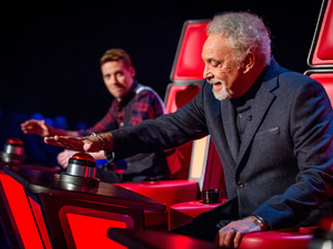 Sir Tom Jones goes to press his button on The Voice UK