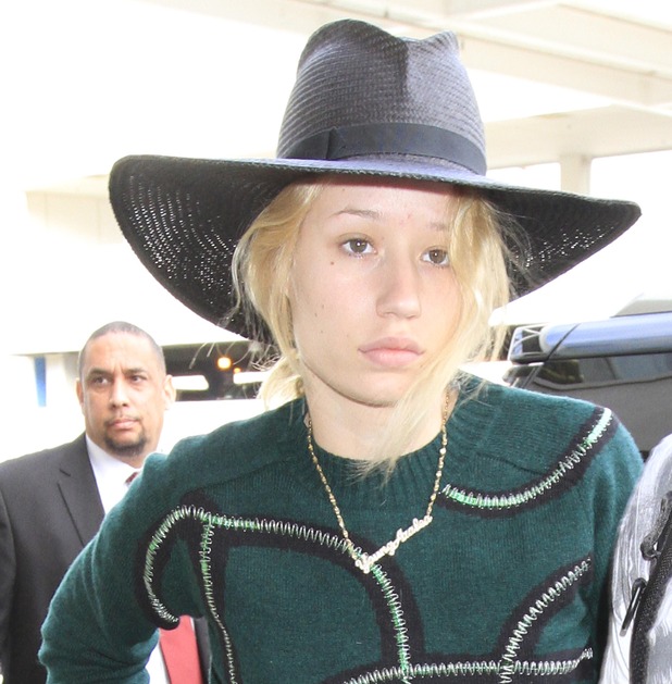 Caption: Iggy Azalea looks half-asleep as she catches a flight out of Los Angeles. The adorable Aussie musician was seen at LAX wearing a green sweater, a long black skirt and a floppy hat, with no makeup. 