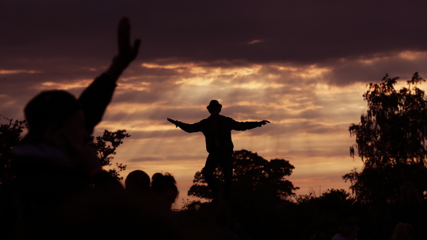 The crowd at the Stone Circle at sunset during the Glastonbury Festival